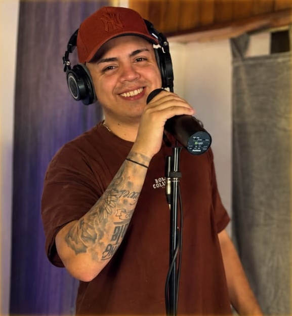 Edgar Hernán sonriendo en el estudio, con auriculares y micrófono